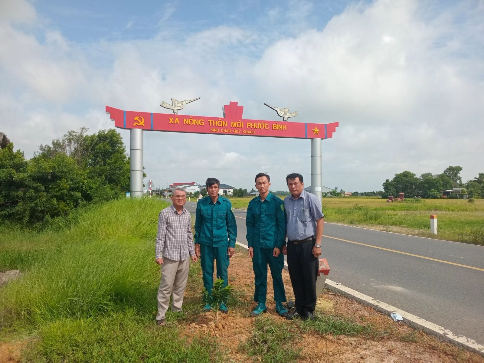 Ông Nguyễn Văn Sáu (bìa trái) đã đóng góp tiền xây dựng cổng chào xã Phước Bình đạt chuẩn nông thôn mới