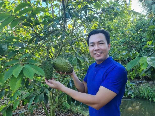 Anh Đậu bên vườn mãng cầu nhà mình