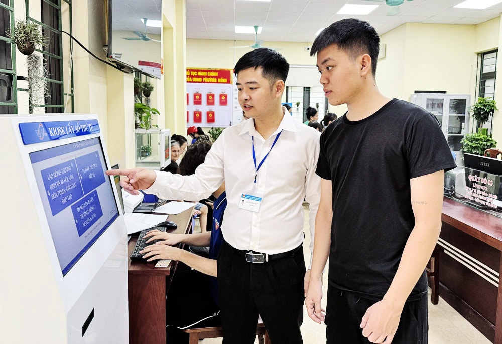 Cán bộ Trung tâm Phục vụ hành chính công phường Nếnh hỗ trợ công dân sử dụng máy bấm số tự động
