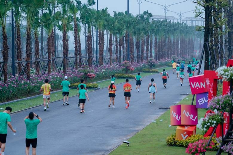 A group of people running on a road Description automatically generated